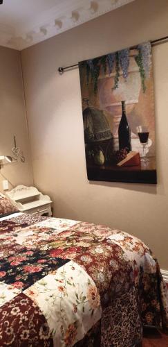 a bedroom with a bed and a painting on the wall at Matai Huka Boutique Accommodation in Paraparaumu