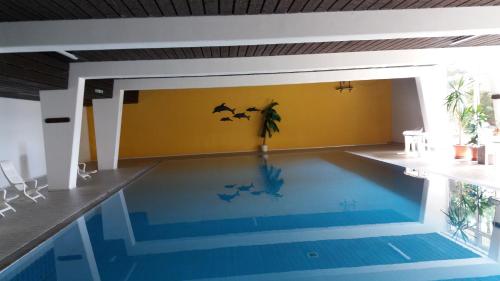 een zwembad in een huis met vleermuizen aan de muur bij Ferienwohnung Reni in Sankt Englmar