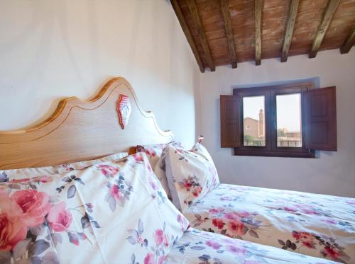 a bedroom with a bed with a wooden head board at Palazzo Piccolomini in Siena