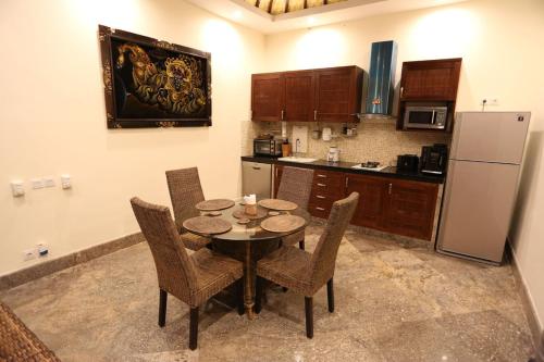 a kitchen with a table and chairs and a refrigerator at Villa Barong in Candidasa