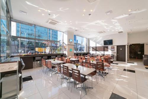 a cafeteria with tables and chairs in a building at Toyoko Inn Seoul Dongdaemun II in Seoul