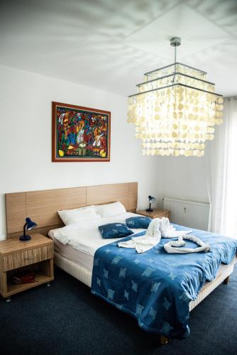 a bedroom with a large bed and a chandelier at Club Onix Apartments in Neptun