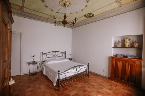 a bedroom with a bed and a chandelier at Il Pozzo Fiorito in Cossombrato