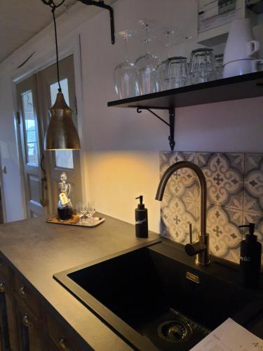 a kitchen with a sink and a counter with glasses at 4B Österlen Bed & Breakfast in Tomelilla