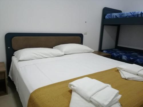 ein Bett mit weißer Bettwäsche und Kissen darauf in der Unterkunft Hotel Tirreno Formia in Formia