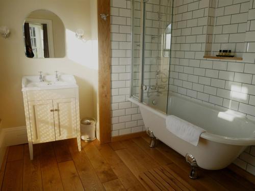 bagno con vasca e lavandino di The White Hart a Whitchurch