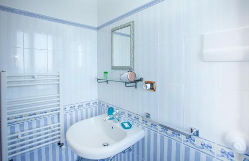 a white bathroom with a sink and a mirror at Isola Bella - Rooms il Pescatore in Taormina