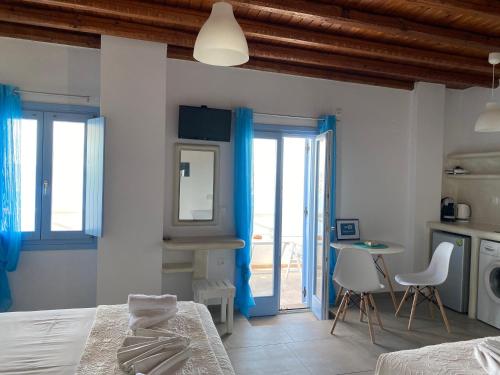 a bedroom with a bed and a table and chairs at Studios Betty in Plaka Milou