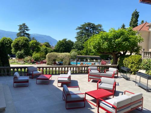 a group of chairs and tables on a patio at Château & Spa De La Commanderie in Eybens