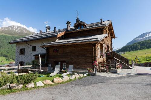 a log cabin with a building in the mountains at Chalet Mistral in Livigno