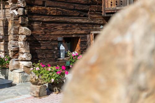 a log cabin with flowers in front of it at Chalet Mistral in Livigno