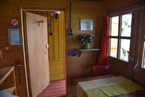 a small room with a door and a table and a window at Countryside Eco Natuurhuisjes in Ee