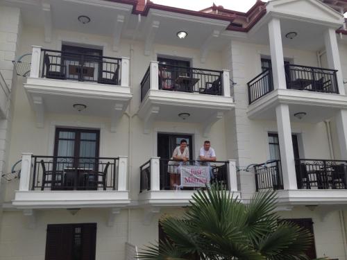 two people standing on a balcony of a building at Makedos Sea View in Nea Vrasna
