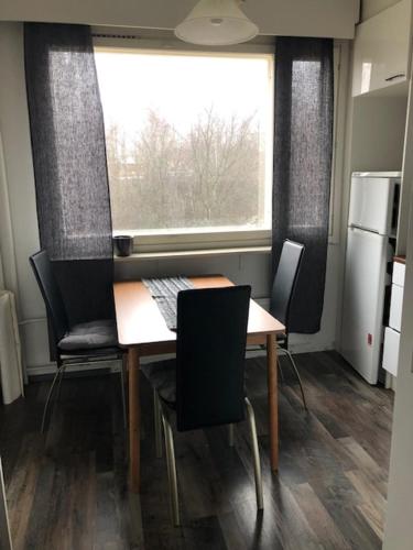 a dining room with a table and chairs and a window at Keskustakoti Jyväskylä in Jyväskylä