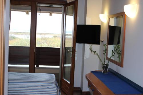 a bedroom with a bed and a mirror and a tv at Hotel Caneo in Fossalòn