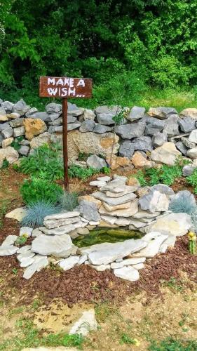 a sign in the middle of a rock garden at Krka Fairytale village in Rupe