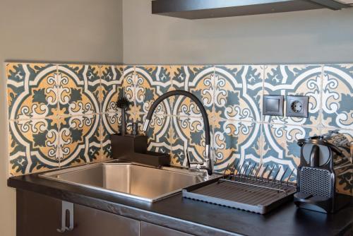 a kitchen with a stainless steel sink and a patterned wall at Urban Sea View Lofts #2 in Chalkida