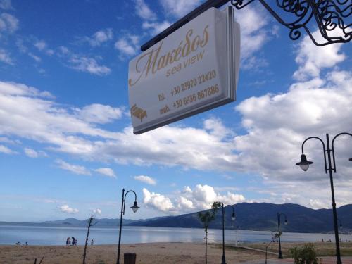a sign on a beach with a view of the water at Makedos Sea View in Nea Vrasna