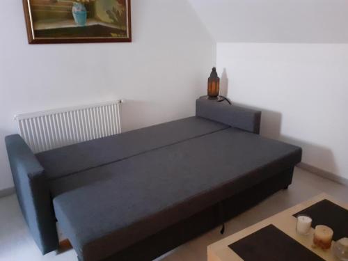a black bed in a room with a table at Studio chaleureux Beauvais-centre, gare et proche Aéroport in Beauvais