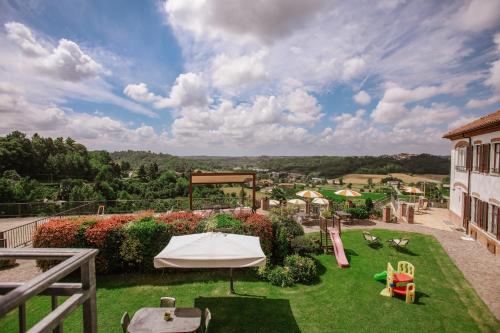 a patio with a lawn with a table and chairs at Il Pozzo Fiorito in Cossombrato