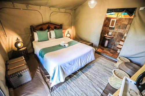 a bedroom with a bed in a tent at Kruger Adventure Lodge in Hazyview