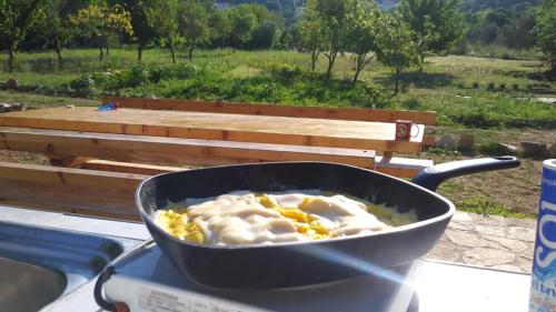 a pan of food on a table with a bench at Krka Fairytale village in Rupe