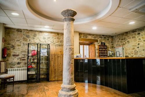 a column in the middle of a room with a bar at Hotel Casa Palacio in Montanejos