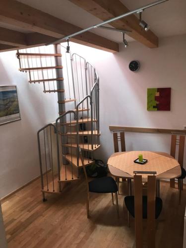 - un escalier en colimaçon dans une chambre avec une table dans l'établissement Wörter Marianne, à Sankt Ulrich am Pillersee
