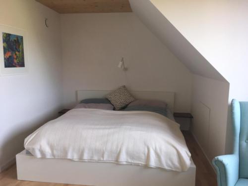 a bedroom with a white bed in a attic at Ferienwohnung Kapellenweg Bambergen bei Überlingen in Bambergen