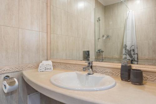 Blue Lagoon Seafront Apartments في مدينة فارنا: حمام مع حوض ومرآة