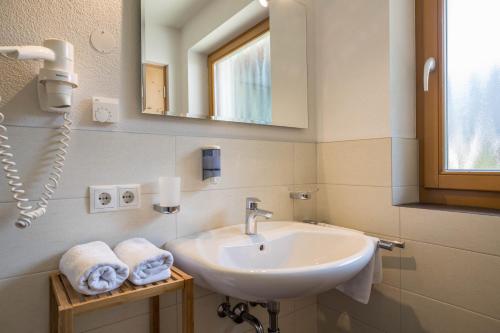 a bathroom with a sink and a mirror and towels at Apartment Alpenrose - Mesnerhof in Campo Tures