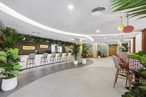 a lobby with plants and a bar at Hotel Riu Concordia in Playa de Palma