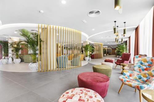 a lobby with colorful chairs and tables and a lobby at Hotel Riu Concordia in Playa de Palma
