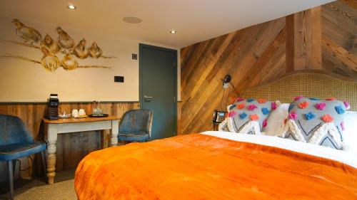 a hotel room with a bed and two chairs at The Farm House in West Malling