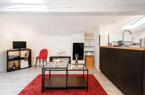 un salon avec une table et un tapis rouge dans l'établissement Le Cocon - Chaleureux Studio Centre Ville au Calme, à Toulouse