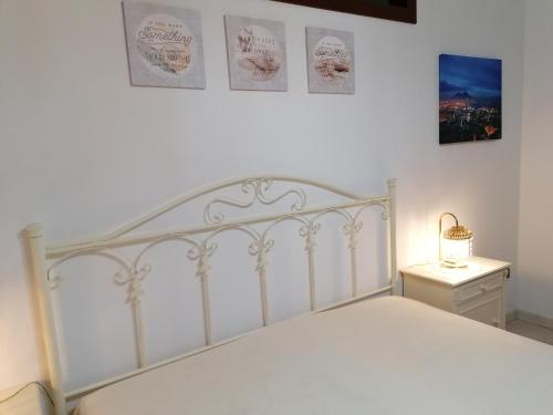 1 dormitorio con cama blanca y cabecero blanco en Casa vacanze Kate en Scanzano