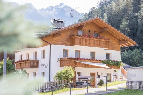 a house with a wooden roof and a balcony at Apartment Kornblume - Mesnerhof in Sand in Taufers
