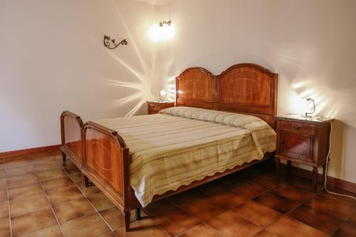 a bedroom with a wooden bed and a night stand at Il Pozzo Fiorito in Cossombrato