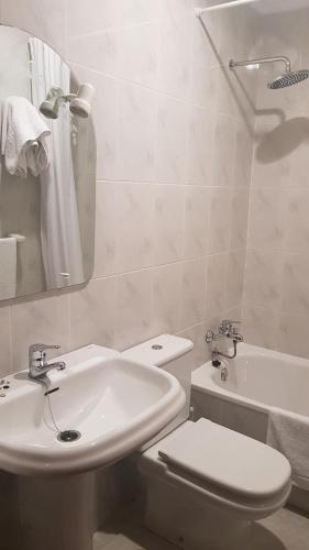 biała łazienka z toaletą i umywalką w obiekcie Casa Fuentes w mieście Poio