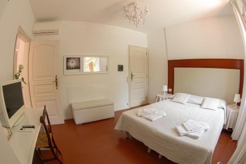 a bedroom with a bed and a desk and a television at Ai Giardini di San Vitale in Ravenna