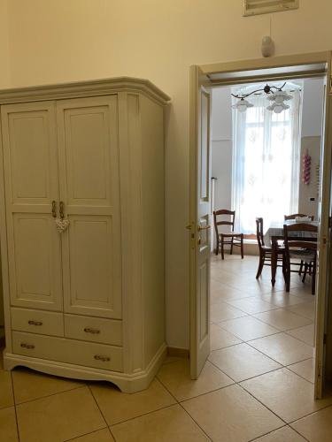 a room with a white cabinet and a dining room at Casa Sirena, Locazione Turistica in Polignano a Mare