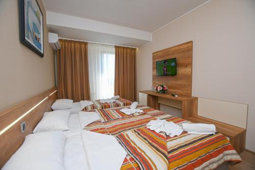 a hotel room with two beds with towels on them at Hotel Djerdap in Kladovo