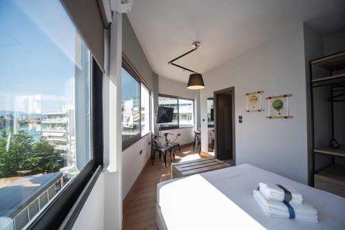 um quarto com uma cama e uma grande janela em Urban Sea View Lofts #3 em Chalkida