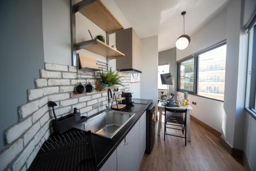 a kitchen with a sink and a brick wall at Urban Sea View Lofts #3 in Chalkida