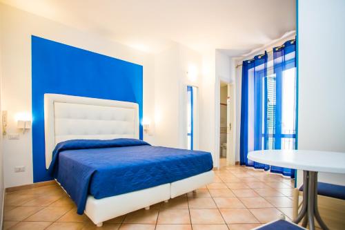 ein blaues Schlafzimmer mit einem Bett und einem Tisch in der Unterkunft La Piazzetta in Amalfi