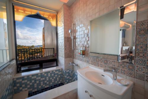 Un baño con lavabo y ventana. en Summer Delight B&B, en Nanwan