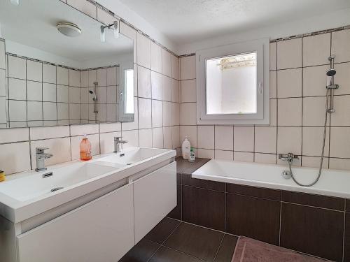 une salle de bain avec un lavabo, une baignoire et un miroir dans l'établissement A la devino, à Fréjus