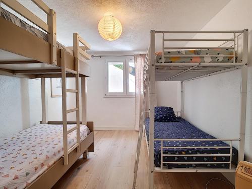 une chambre avec deux lits superposés et une fenêtre dans l'établissement A la devino, à Fréjus
