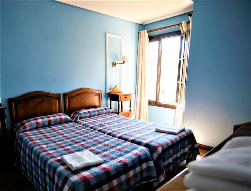 1 dormitorio azul con 1 cama con manta a cuadros en Duplex 6 pax con Wifi en Bahia Sur con parking y piscinas comunitarias, en San Fernando