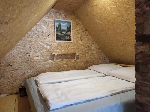 een bed in een kamer met een stenen muur bij Ele kodumajutus in Pärnu